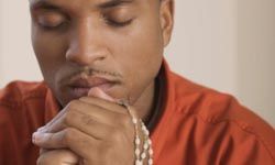 man meditating with beads