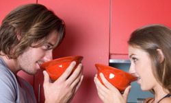 man and woman sipping soup