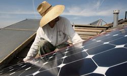 Employees of a solar company install panels on a residential rooftop in Santa Monica, Calif.