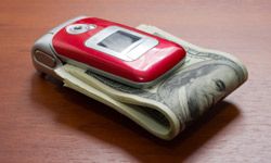 cell phone clamped over folded bills
