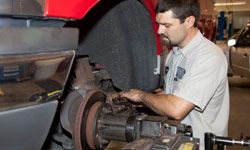 A mechanic works on a vehicle's brakes