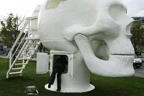 一个女人正内•范Lieshout的“健康Skull"在维也纳,Karlsplatz在其2008年的展览。”border=