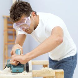 man using saw to cut wood