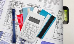 blueprints, credit cards, calculator and other tools related to construction