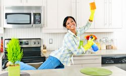 woman cleaning kitchen happily