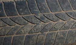 Evidence of flat rubber bars running perpendicular to the direction of the tread indicate you need new tires.