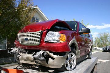 crumpled car being towed away