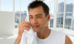 Man wiping face with towel