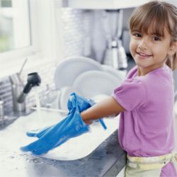 Little girl doing dishes and wearing gloves