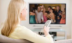 Woman watching TV with remote control