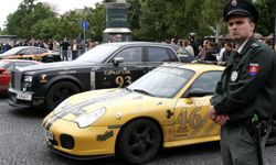 A Slovakian policeman stands next to the cars of Gumball 3000 rally competitors in front of The Carlton hotel on May 4, 2007, in Bratislava, Slovakia.