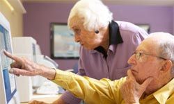 caucasian senior citizen couple working at computer