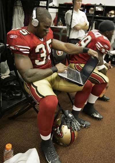 Thomas Clayton #35 of the San Francisco 49ers uses his laptop in the locker room before a pre-season game.