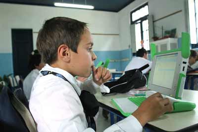 A fourth degree schoolboy works in the classroom with his OPLC laptop