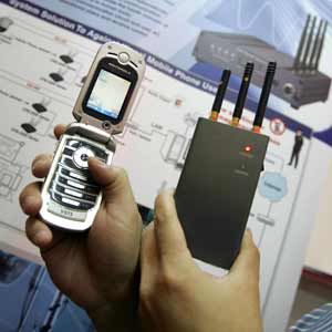 A trade exhibitor shows a portable pocket-sized cell phone jammer CPB-2000P 