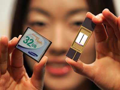 An employee of Samsung Electronics Co., Ltd., shows new 32-Gigabyte NAND memory chip (R) and card (L).
