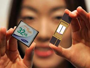 An employee of Samsung Electronics Co., Ltd., shows new 32-Gigabyte NAND memory chip (R) and card (L).