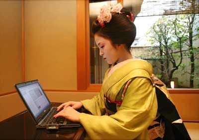 Ichimame, an 19-year-old maiko or young geisha, sits at a computer to write her internet blog at a teahouse in Japan.